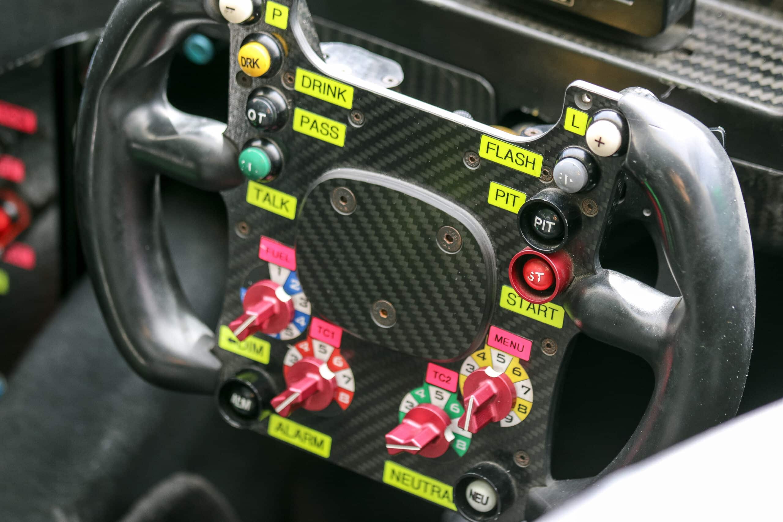 Close-up of a Formula One racing steering wheel with labeled controls, symbolizing complex operations in private equity.